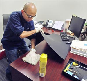 Miguel Moreno polishes a desk at Royal Business Bank in San Gabriel Thursday Oct. 29, 2009.